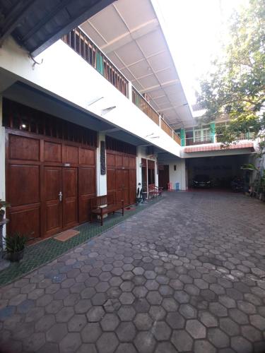 a large building with wooden doors and a courtyard at Ki Agung Prestise Hotel in Timuran