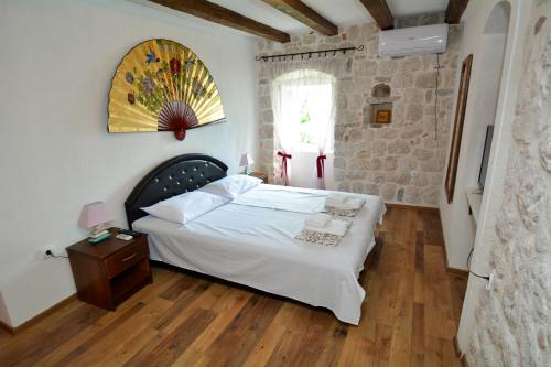 a bedroom with a white bed and a window at Apartments Krivokapic in Perast