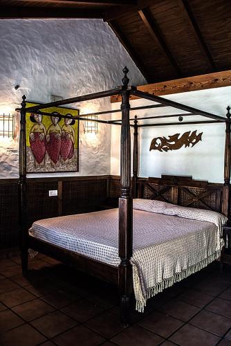 a bedroom with a four poster bed in a room at Complejo Vacacional Los Cortijillos-Solo adultos in Conil de la Frontera