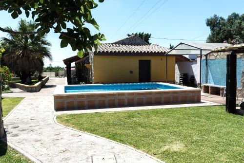 een huis met een zwembad in een tuin bij Complejo Vacacional Los Cortijillos-Solo adultos in Conil de la Frontera