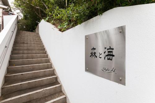 a sign on a wall next to a staircase at Ise Shima Moritoumi in Shima