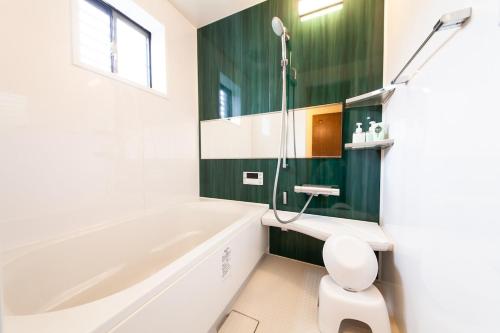 a bathroom with a white tub and a toilet at Ise Shima Moritoumi in Shima