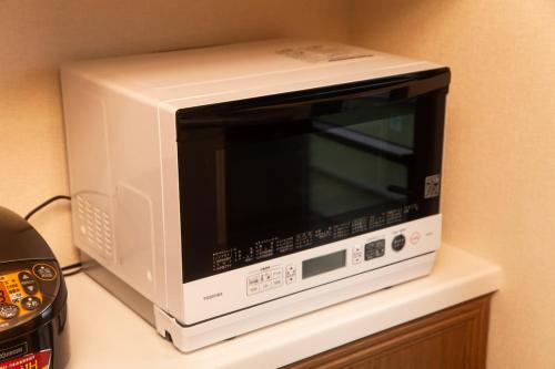 a white microwave sitting on top of a counter at Ise Shima Moritoumi in Shima