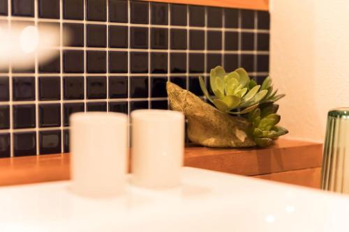 a group of three candles on a counter with a plant at Ise Shima Moritoumi in Shima