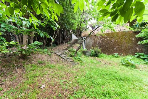 a garden with a stone path next to a wall at Ise Shima Moritoumi in Shima