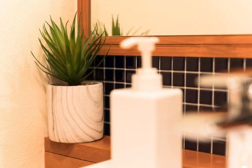 a bathroom with a bottle of soap and a plant at Ise Shima Moritoumi in Shima