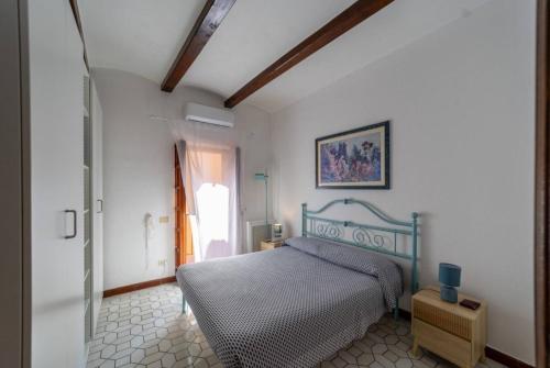 a bedroom with a bed in a room with a window at Porto Ercole Vacation Home in Porto Ercole