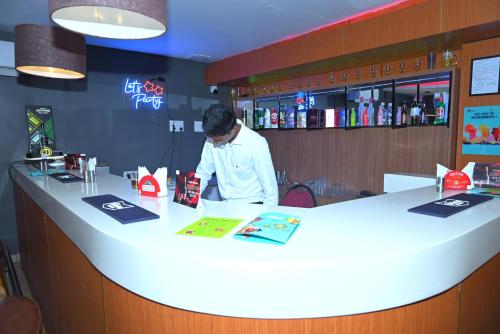 a man standing at a counter in a restaurant at Hotel TamilNadu, Madurai II in Madurai