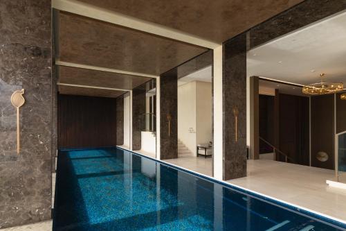an indoor swimming pool with blue water in a building at SOMA HOTEL Riverside in Phnom Penh