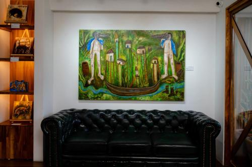 a couch in a room with a painting on the wall at Casa de Arte Hotel Boutique in Oaxaca City