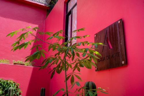 a pink wall with a sign on a building at Casa de Arte Hotel Boutique in Oaxaca City
