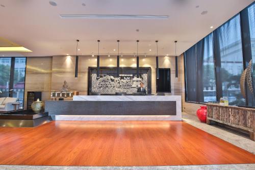 a lobby with a reception desk in a building at SSAW Boutique Hotel Qidong Tiansheng in Qidong