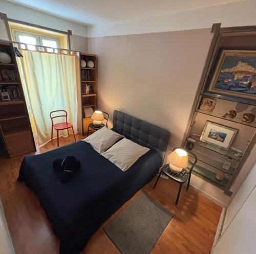 a bedroom with a blue bed and a window at Room for NUDISTS near Nice port in a shared apartment in Nice