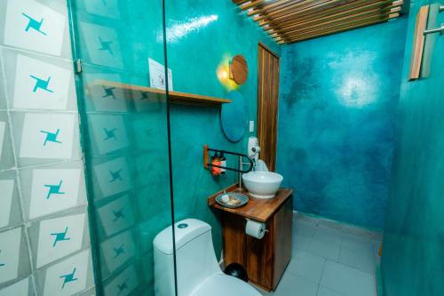 a blue bathroom with a sink and a toilet at Casa de Arte Hotel Boutique in Oaxaca City