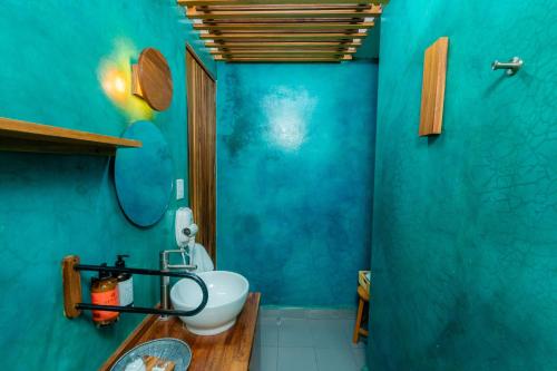 a blue bathroom with a toilet and a sink at Casa de Arte Hotel Boutique in Oaxaca City