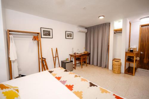 a bedroom with a bed and a table and a desk at Casa de Arte Hotel Boutique in Oaxaca City