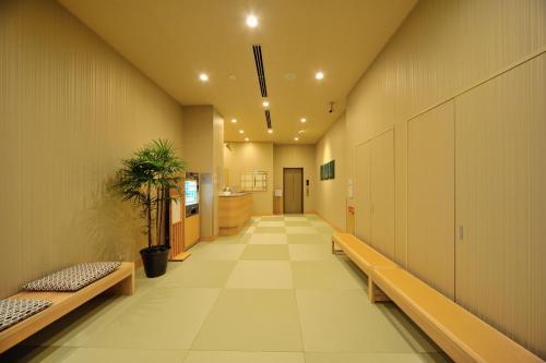 an empty hallway with benches in a building at Onyado Nono Toyama Natural Hot Spring in Toyama