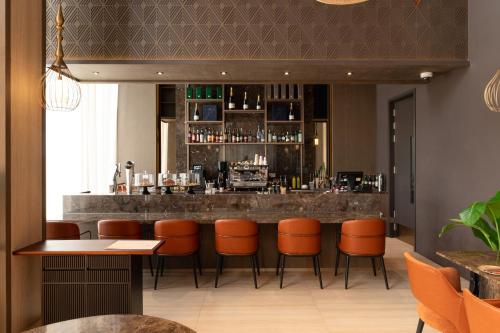 a bar in a restaurant with orange bar stools at SOMA HOTEL Riverside in Phnom Penh