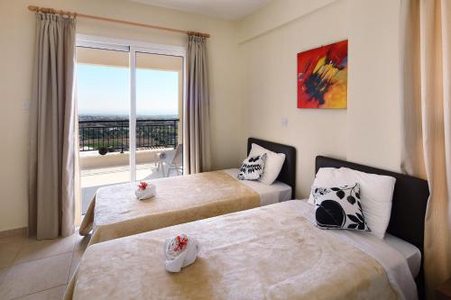 a hotel room with two beds and a window at Club St. George in Paphos City
