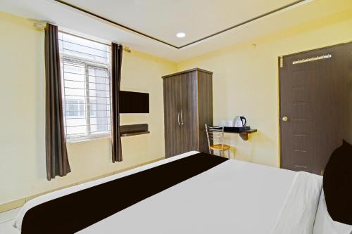a bedroom with a large bed and a window at Super Hotel O Kondapur Hyderabad Formerly Dunes Inn in Hyderabad