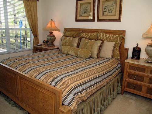 - une chambre avec un grand lit et 2 tables de chevet dans l'établissement Villa 7716 Comrow Windsor Hills, à Orlando
