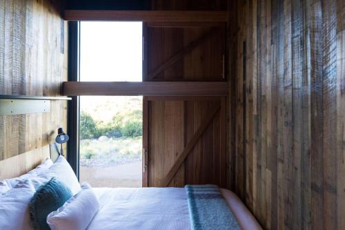 a bedroom with a bed with a large window at Spring Bay Mill in Triabunna