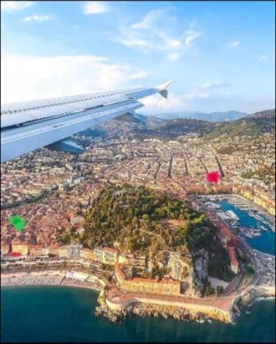 a view of an airplane wing flying over a city at Room for NUDISTS near Nice port in a shared apartment in Nice