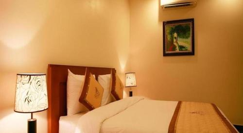a bedroom with a bed and a picture on the wall at Duy Anh Hotel in Hải Dương