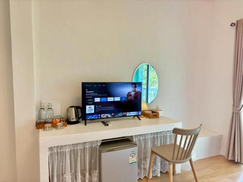 a living room with a television on a counter at Charisma Resort in Ratchaburi