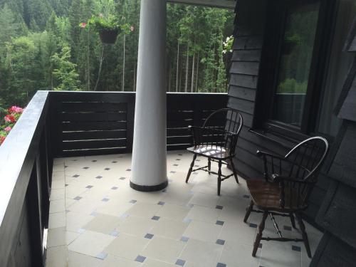 a porch with two chairs and a white pole at Hunting Lodge Vitkov in Sokolov