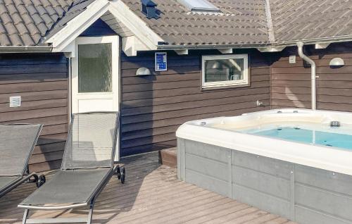 a hot tub sitting on a deck next to a house at Holiday Home Vibelunden Rødby X in Kramnitse