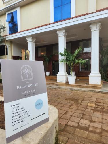 a sign in front of a building at The Palm House in Canacona