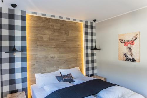 Schlafzimmer mit einem Bett mit einem Kopfteil aus Holz in der Unterkunft Kandahar Lodge in Garmisch-Partenkirchen