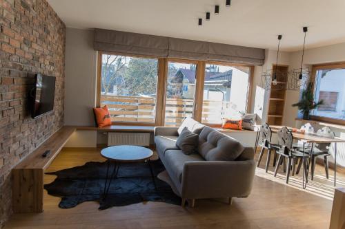 a living room with a couch and a brick wall at Kandahar Lodge in Garmisch-Partenkirchen