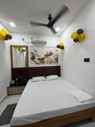 a bedroom with a bed with yellow balloons on the wall at Mahaveer Lodge in Siliguri