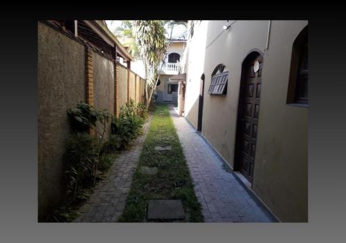 a narrow alley with a building and a door at Pousada Canto de Bertioga in Bertioga