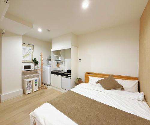 東京にあるTokyo Ueno Mia Hotelの大きなベッドとキッチンのある寝室