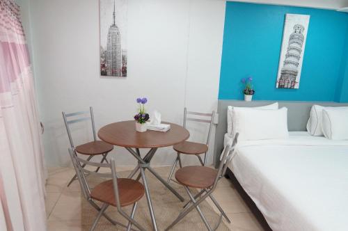 a bedroom with a table and chairs next to a bed at Ma Non Nont Hotel & Apartment in Nonthaburi