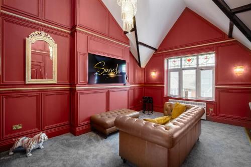a living room with red walls and a couch at Swish Luxury Holiday Apartments 2 in Blackpool