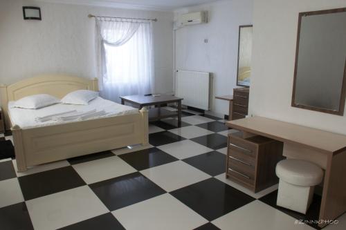 a bedroom with a bed and a checkered floor at Kedem Hotel in Lipiny