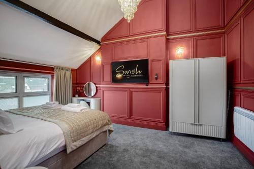 a red room with a bed and a refrigerator at Swish Luxury Holiday Apartments 2 in Blackpool