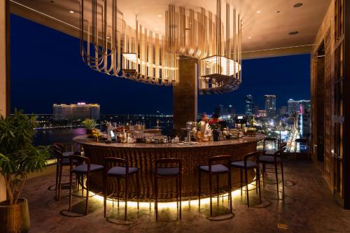 a restaurant with a bar with a view of the city at SOMA HOTEL Riverside in Phnom Penh