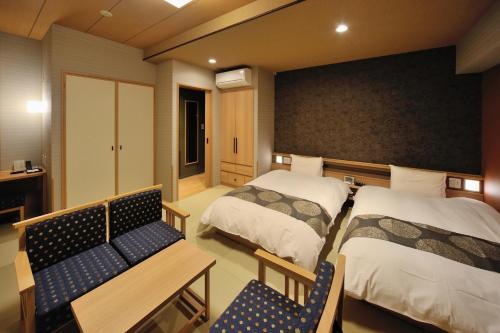 a hotel room with two beds and a bench at Onyado Nono Toyama Natural Hot Spring in Toyama
