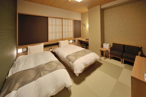 um quarto de hotel com duas camas e uma televisão de ecrã plano em Onyado Nono Toyama Natural Hot Spring em Toyama