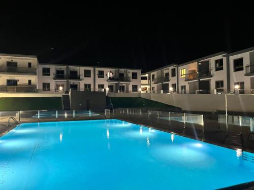 an empty swimming pool in front of buildings at night at El beso del mar in Costa de Antigua