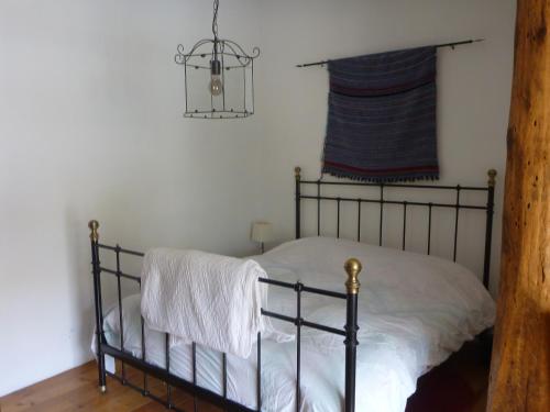 a bedroom with a bed with white sheets and a window at Gite Sent Martin in Roquefixade