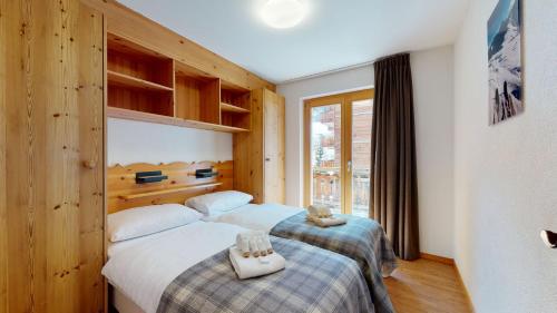 a hotel room with two beds and a window at Pracondu 1 406 - OUTDOOR & FUN charming apartment in Nendaz