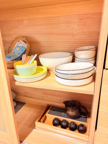 a cabinet filled with bowls and plates and other dishes at 捉鳳凰 台南百年老宅包棟導覽民宿系列Catchphoenix Centennial Guesthouse in Tainan