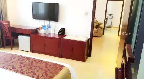 a bedroom with a bed and a flat screen tv at Jian Guo Grand Hotel in Vientiane