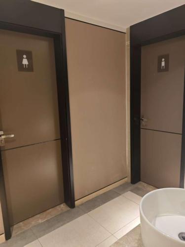 a bathroom with two sliding doors and a sink at Orange Hotel Beijing Temple of Heaven North Gate in Beijing